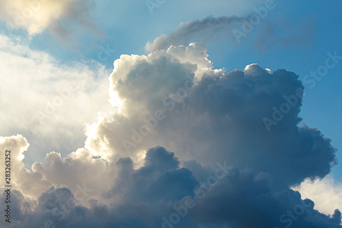 large cumulus, nimbus clouds with silver lining, in blue, and white