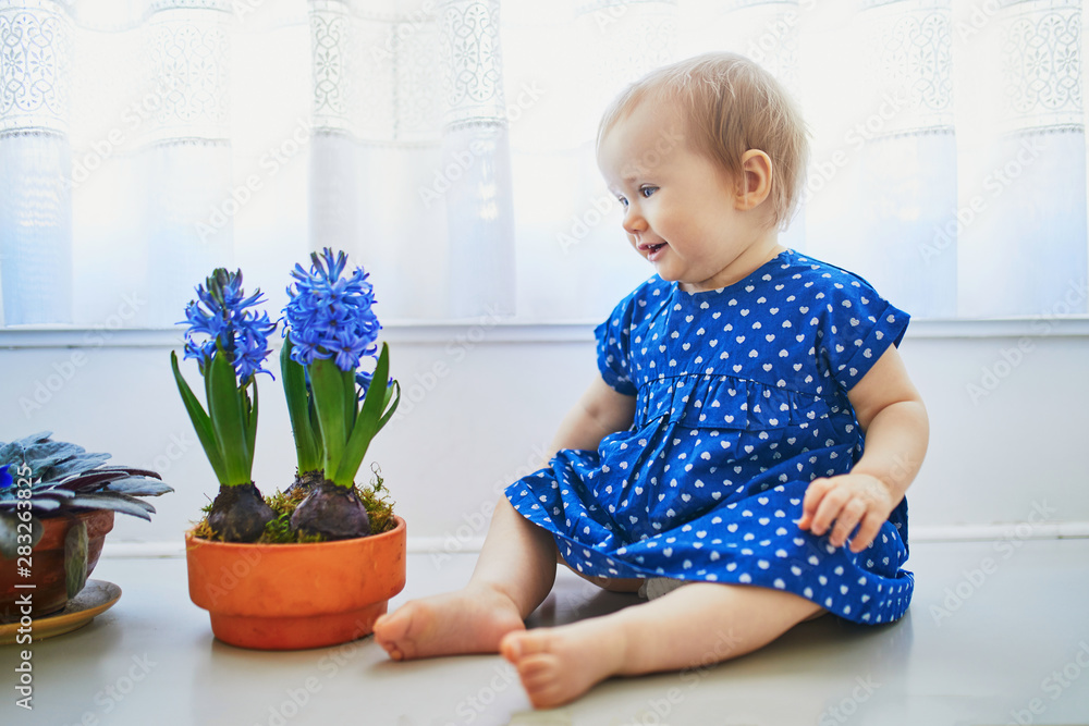 Baby girl in blue dress with hyacinths Baby girl in blue dress with hyacinths