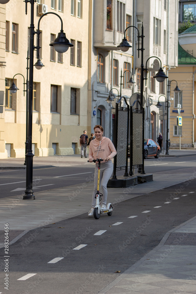 woman moving down the street on scooter