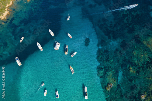 View from above, stunning aerial view of a beautiful bay full of boats and luxury yachts. A turquoise sea bathes the green and rocky coasts. Liscia Ruja, Emerald Coast (Costa Smeralda) Sardinia, Italy