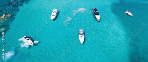View from above, stunning aerial view of a beautiful bay with turquoise water full of boats and luxury yachts. Liscia Ruja, Emerald Coast (Costa Smeralda) Sardinia, Italy.