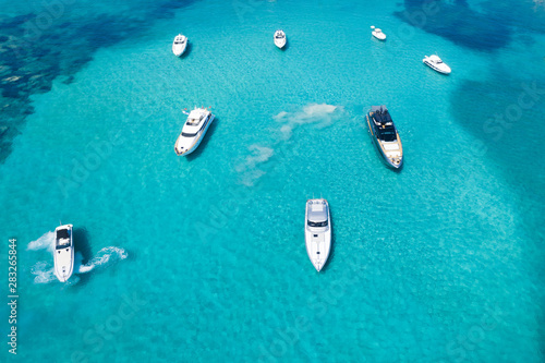 View from above, stunning aerial view of a beautiful bay with turquoise water full of boats and luxury yachts. Liscia Ruja, Emerald Coast (Costa Smeralda) Sardinia, Italy.
