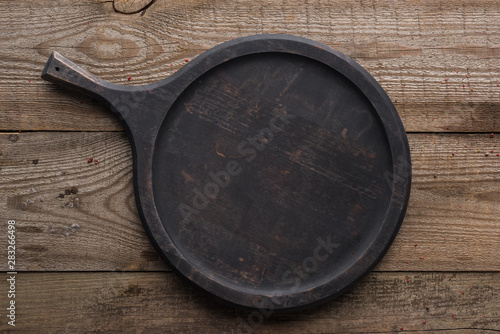 top view of empty woode pizza pan on textured table