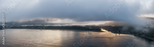Fototapeta Naklejka Na Ścianę i Meble -  Aerial Panoramic View of a small secluded town on the Pacific Ocean Coast during a cloudy summer sunrise. Taken in Port Renfrew, Vancouver Island, BC, Canada.