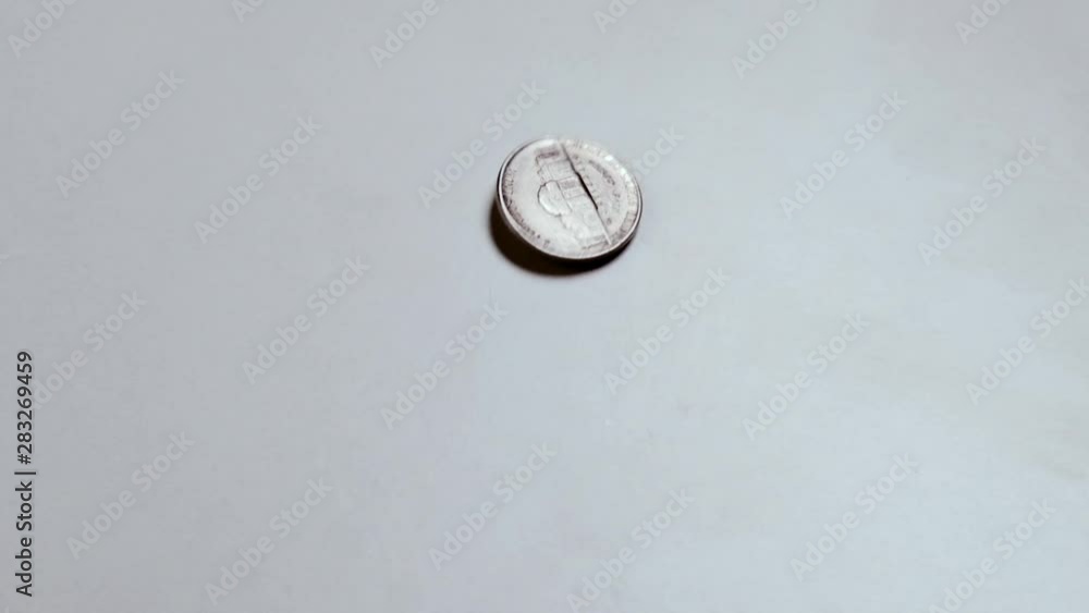 Five American cents on a white table. The coin spins and stops.Small cash metal funds. Five American cents on a white table. The coin spins and stops.Small cash metal funds.