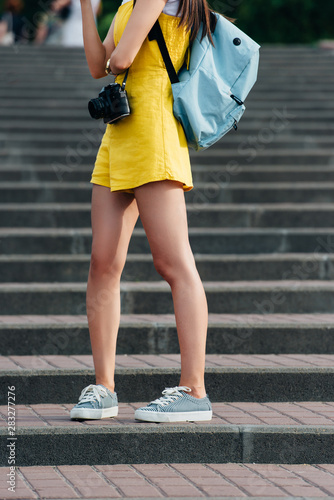 cropped view of woman in overalls with digital camera