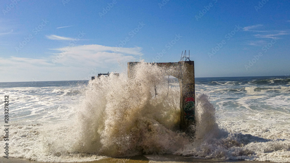 Waves crashing on abandoned dock posts