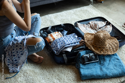 Photography Beautiful woman arrange clothes in travel luggage,happy in holiday trip