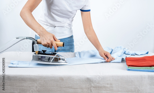 A family woman is ironing clothes at home