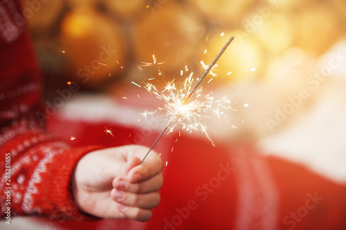 Hand with burning christmas sparkler. Close-up.