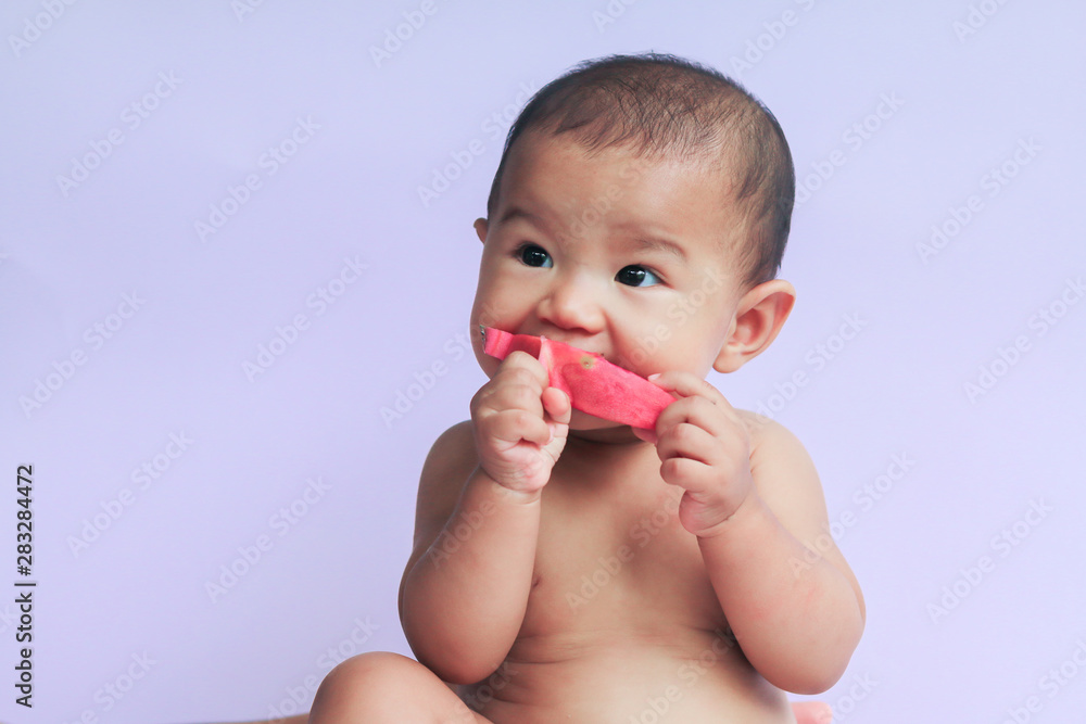 asian cute baby girl eating red dragon fruit. newborn baby on white background asian cute baby girl eating red dragon fruit. newborn baby on white background