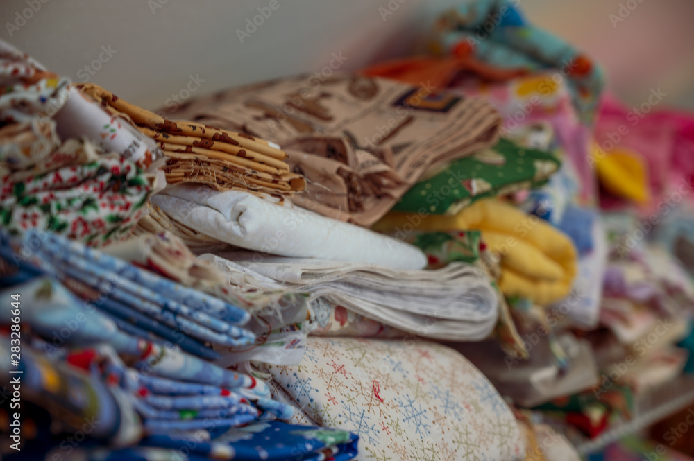 Assorted pile of fabric and bolts of cloth Assorted pile of fabric and bolts of cloth