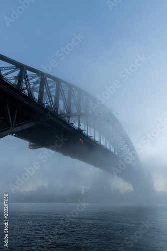 Morning blue hour view of Sydney Harbour Bridge with some fog.