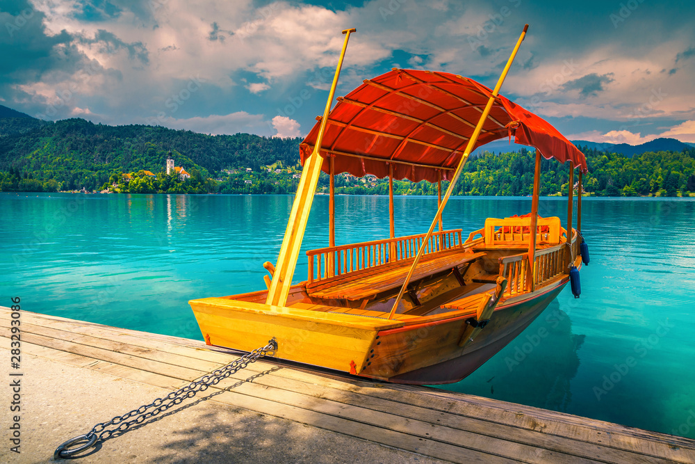 Wooden Pletna boat on the lake Bled with small island
