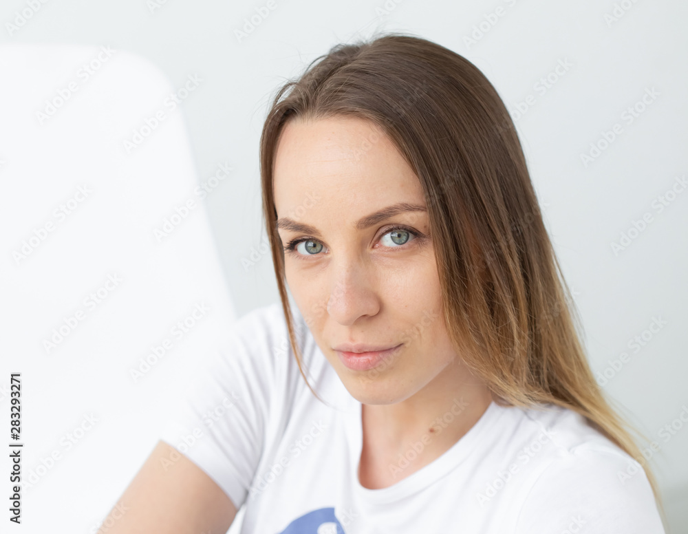 Close-up of pretty good looking stylish woman posing on white wall background. The concept of a strong independent purposeful young woman. Close-up of pretty good looking stylish woman posing on white wall background. The concept of a strong independent purposeful young woman.