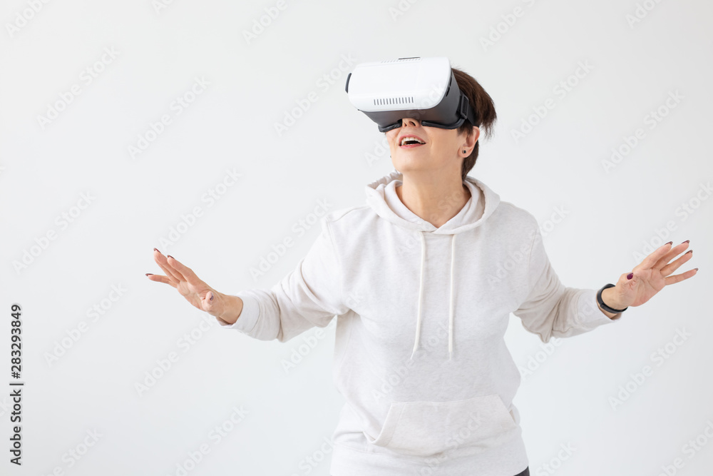 Modern technologies, future and people concept - Woman 40-50 years old wearing virtual reality glasses on white background Modern technologies, future and people concept - Woman 40-50 years old wearing virtual reality glasses on white background