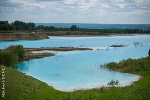 Fototapeta Naklejka Na Ścianę i Meble -  Alkaline solution. Ash dump dumping waste into the water. Ecological catastrophy. Turquoise dead water is like an oasis. The result of the waste plant.