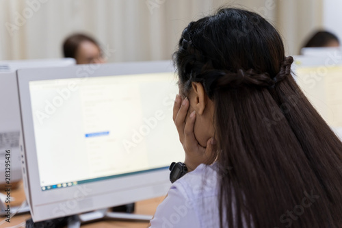 Blur and selective focus of the university student using computer studying in computer room. Group of students in study in computers room. Serious students working on computer at university.