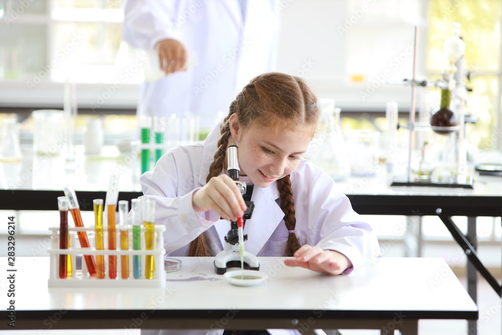 curious kid girl having fun on experimenting science with microscope and smiling face (education and scientist concept) curious kid girl having fun on experimenting science with microscope and smiling face (education and scientist concept)