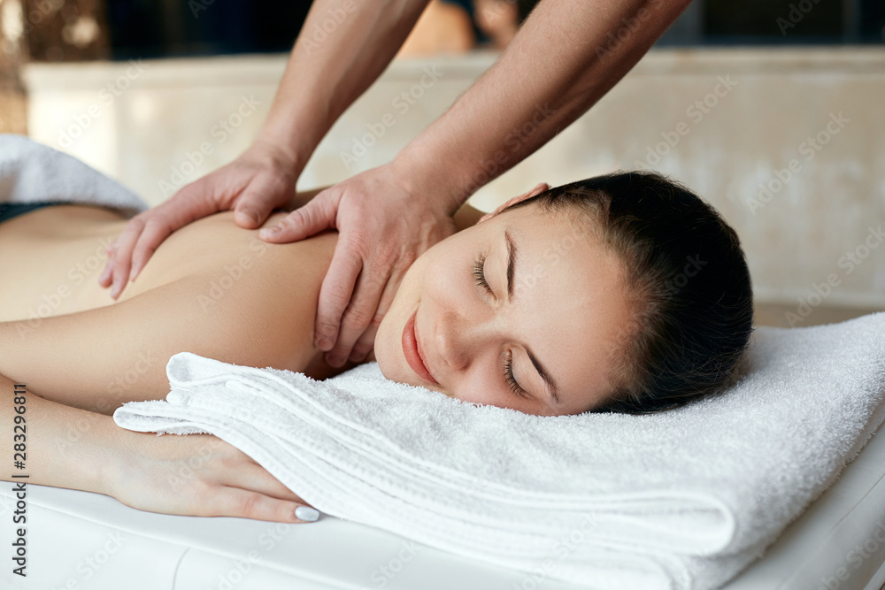 Masseur doing massage on woman body in the spa salon. Beauty treatment concept. Body care. Girl having massage in the spa salon Masseur doing massage on woman body in the spa salon. Beauty treatment concept. Body care. Girl having massage in the spa salon