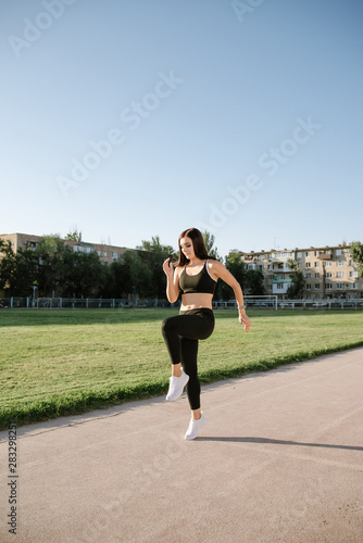 Young woman running during sunny morning on stadium track © bo.kvk