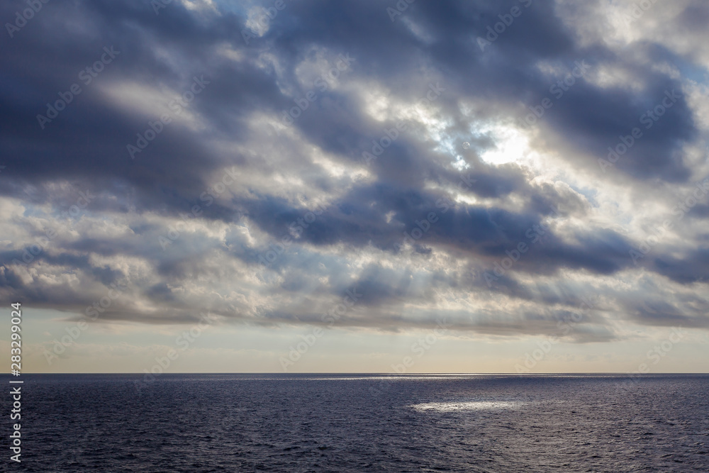 rays of the sun filtering through the clouds over the sea