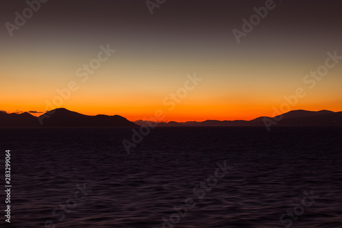 Last lights of the sunset and colorful sky on the islands of the Aegean sea