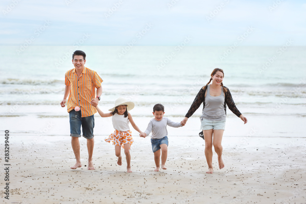 happy asian family dad and mom with their children boy and girl running together with happy laughing face on sandy beach during sunny day happy asian family dad and mom with their children boy and girl running together with happy laughing face on sandy beach during sunny day