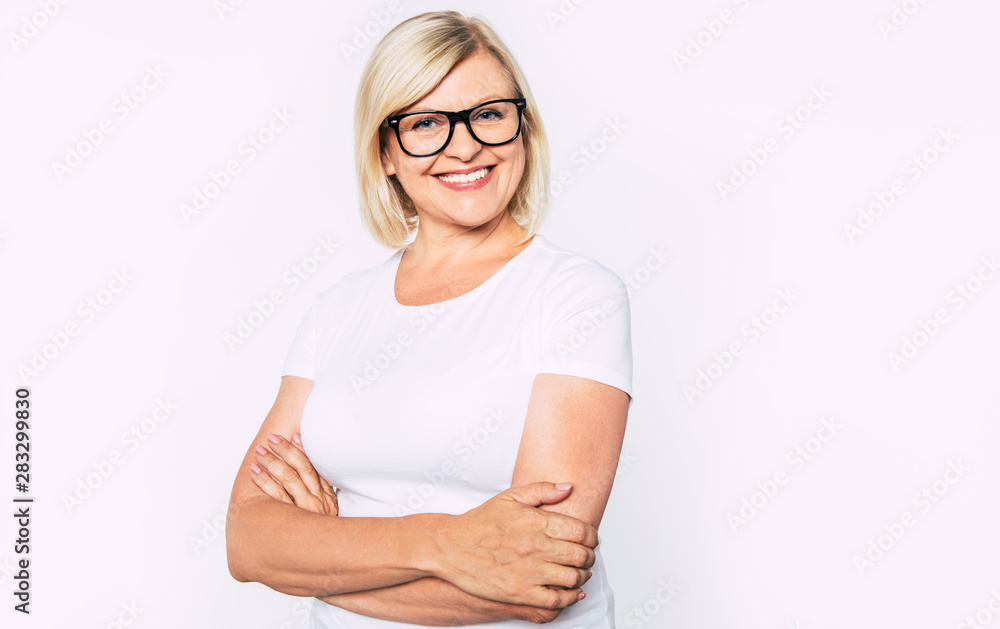Close up portrait of happy smiling and beautiful blonde senior woman isolated in studio and posing with smile on camera Close up portrait of happy smiling and beautiful blonde senior woman isolated in studio and posing with smile on camera