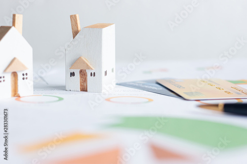 Property investment, Miniature white houses with credit cards and financial documents on table