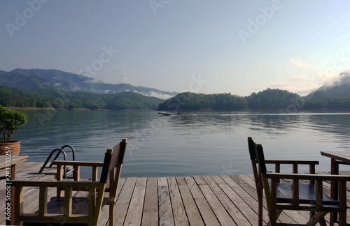 Dining table by the terrace on the middle of the water Behind the mountains Fog in the morning