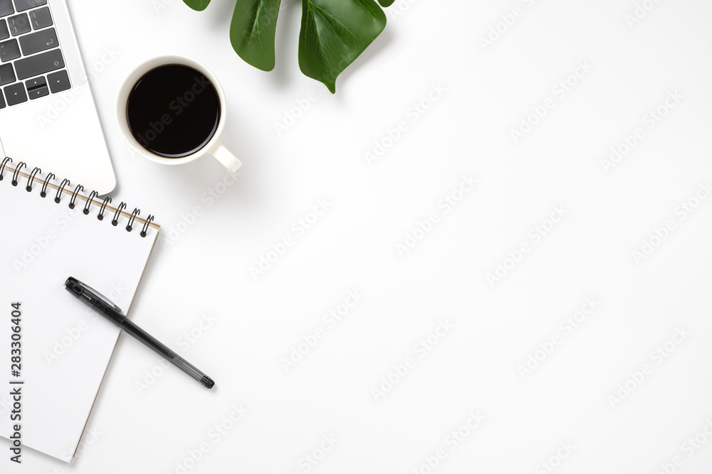 Office desk with laptop, blank notepad, pen coffee and green leaf. flat lay with copy space. Office desk with laptop, blank notepad, pen coffee and green leaf. flat lay with copy space.