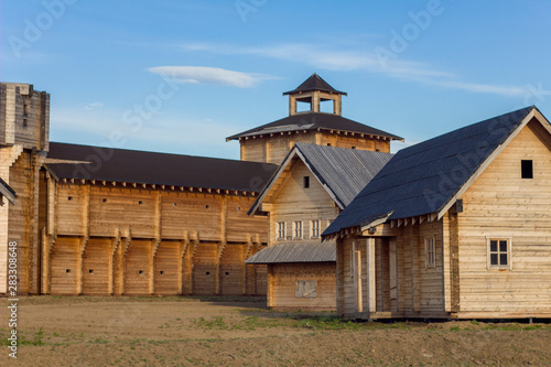 courtyard of an ancient reconstructed wooden fortress with high walls and a tower