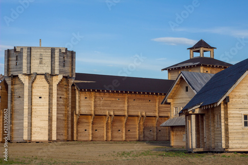 courtyard of an ancient reconstructed wooden fortress with high walls and a bell tower