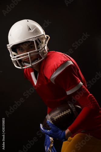 Photo of rugby player sportswoman looking into camera on empty black background
