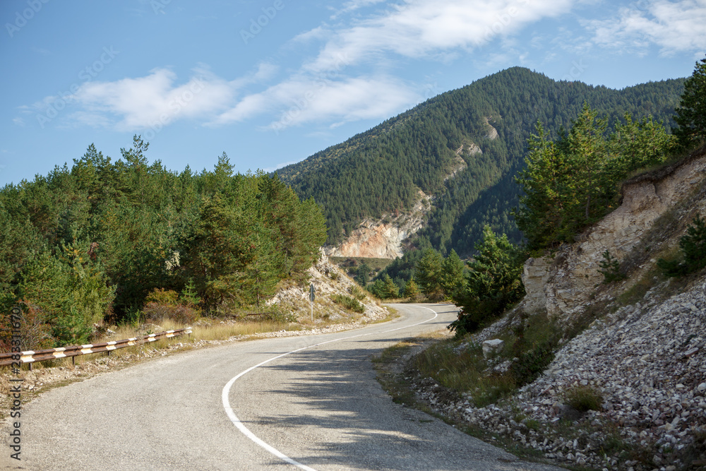 Photo of picturesque mountain area, road, blue sky with clouds