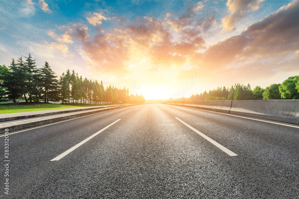 Country asphalt road and green woods nature landscape at sunset Country asphalt road and green woods nature landscape at sunset