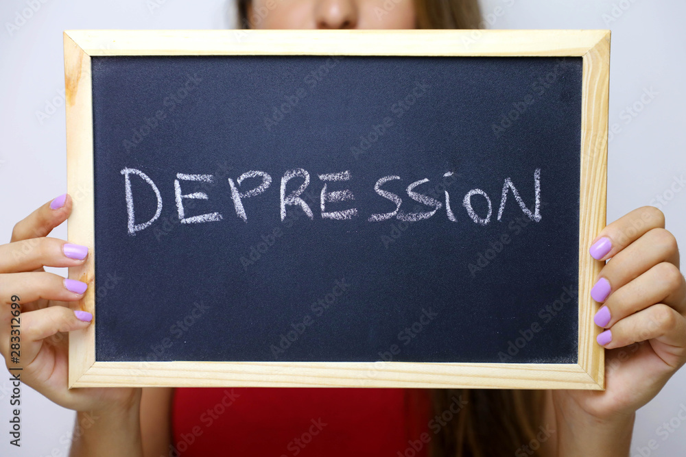 Depression written on the blackboard holding by young unidentified woman. Depression written on the blackboard holding by young unidentified woman.