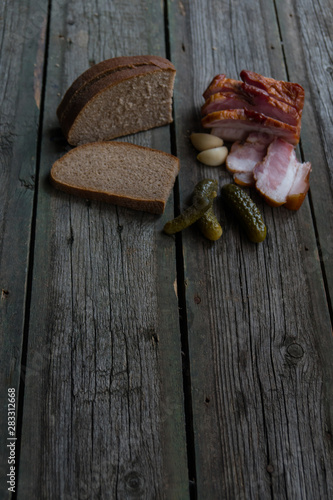 Snacks, bacon, pickled cucumbers on wooden background