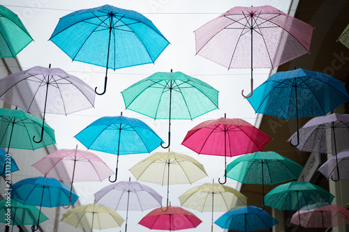 Multi-colored umbrellas in the sky on heavy rainy days