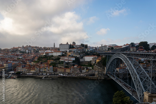 View to the old city of Porto with the D. Luis bridge and colorful buildings. cloudy sky.