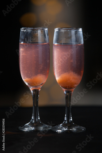 Glasses with a pink drink on a background of illumination