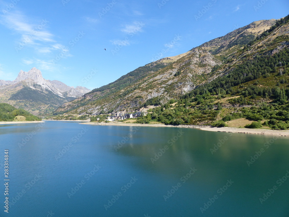 Pueblo en lago entre montañas Pueblo en lago entre montañas