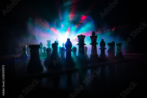 Chess board game concept of business ideas and competition. Chess figures on a dark background with smoke and fog.