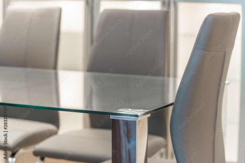 Empty glass table and dark chairs Empty glass table and dark chairs