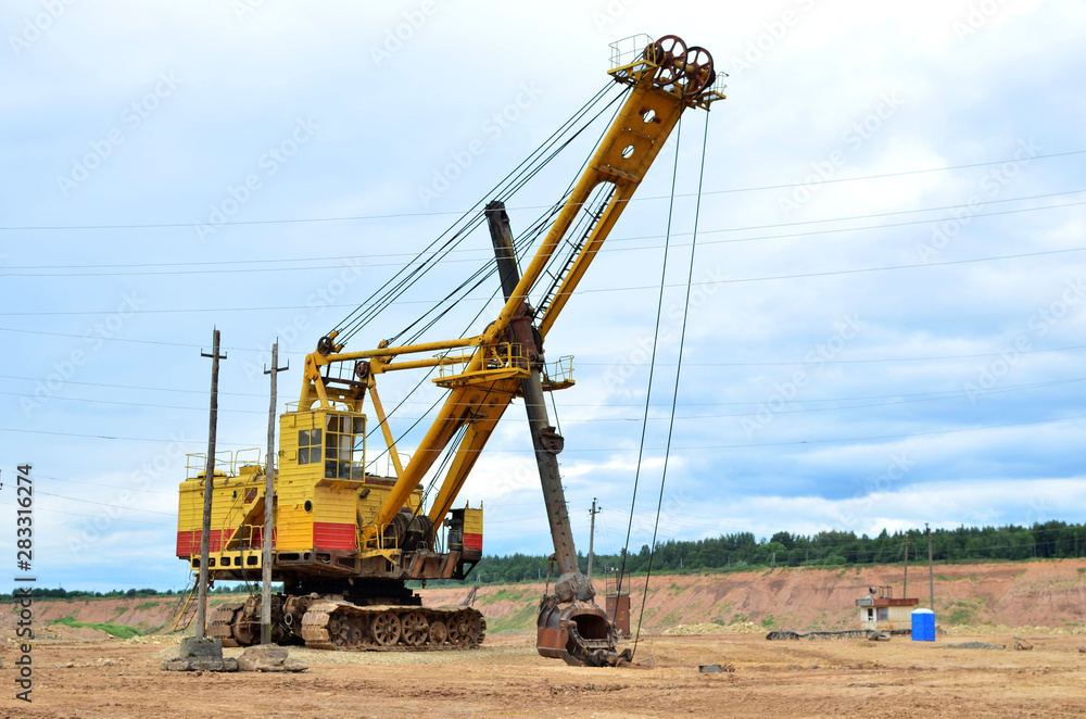 Huge mining excavator in the limestone open-pit. Biggest digger working in dolomite quarry. Largest tracked machine with electric shovel. Heavy duty electric-powered mining equipment - Image