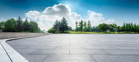 Empty square floor and green woods natural scenery in city park