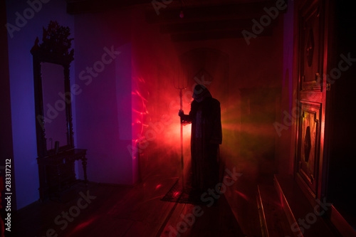 Horror silhouette of ghost inside dark room with mirror Scary halloween concept Silhouette of witch inside haunted house with fog and light on background.