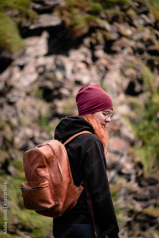 A young woman next to the waterfall at the Gorsa Bridge in the Kåfjorddalen valley A young woman next to the waterfall at the Gorsa Bridge in the Kåfjorddalen valley