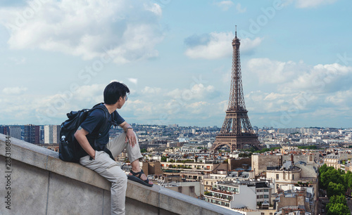 Photography a man with backpack looking at Eiffel tower, famous landmark and travel destinat